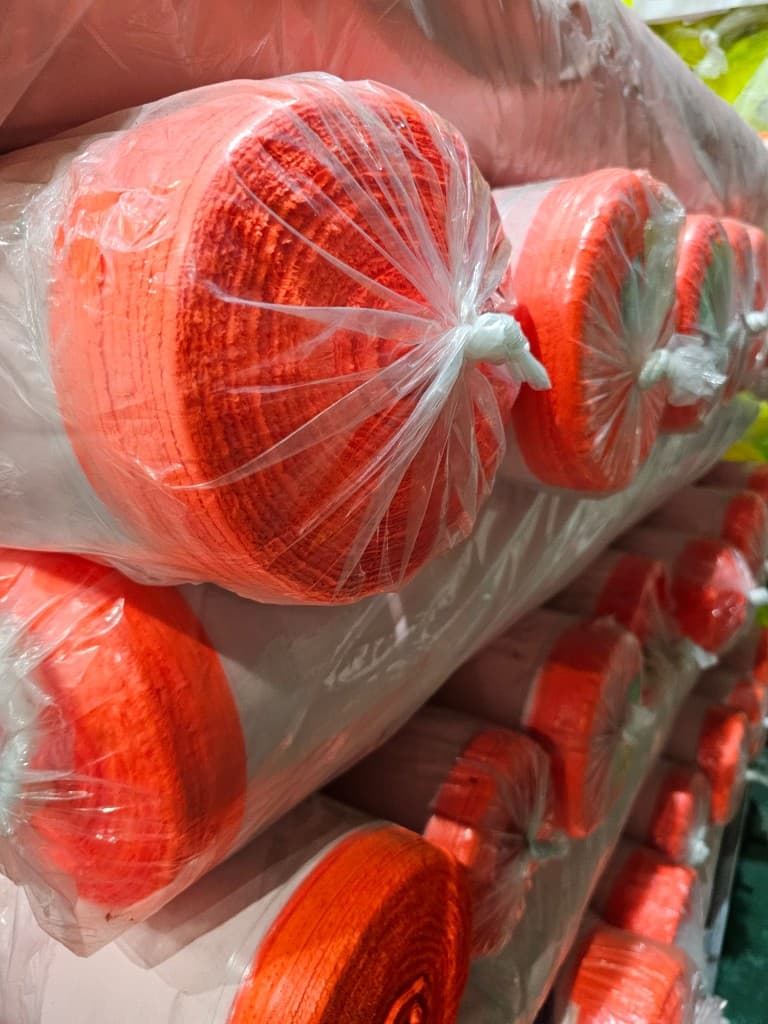 Fluorescent hi-vis fabric rolls in Bangladesh warehouse storage
