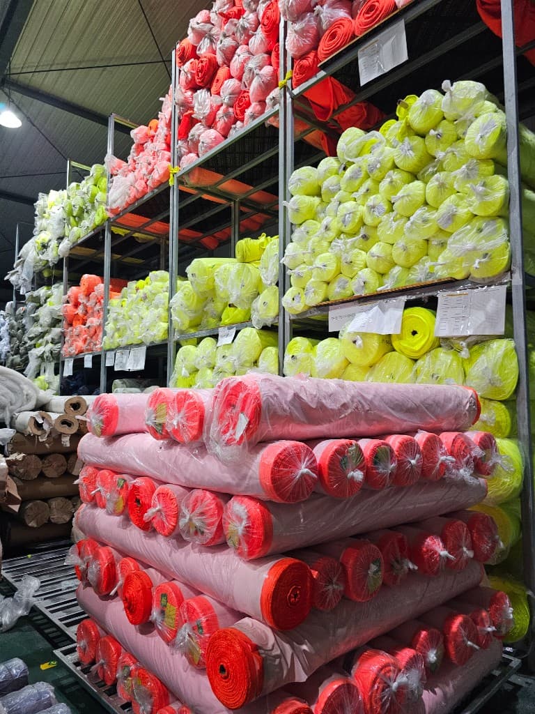 Fluorescent hi-vis fabric stacks in warehouse storage