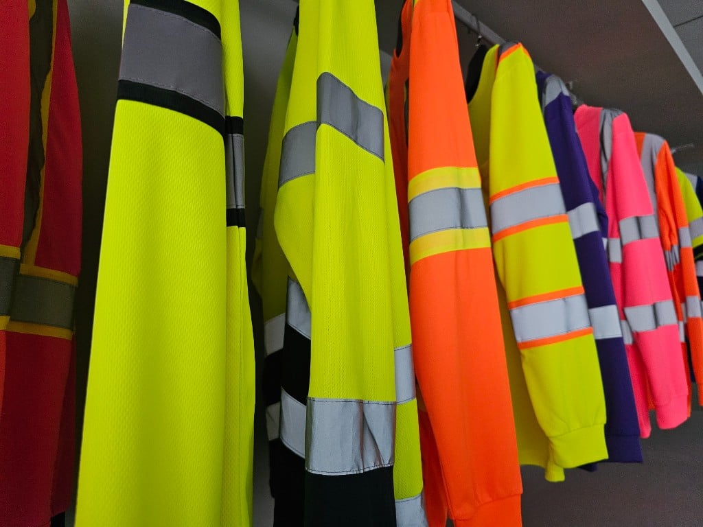 Hi-vis safety sweaters and workwear on showroom display rails