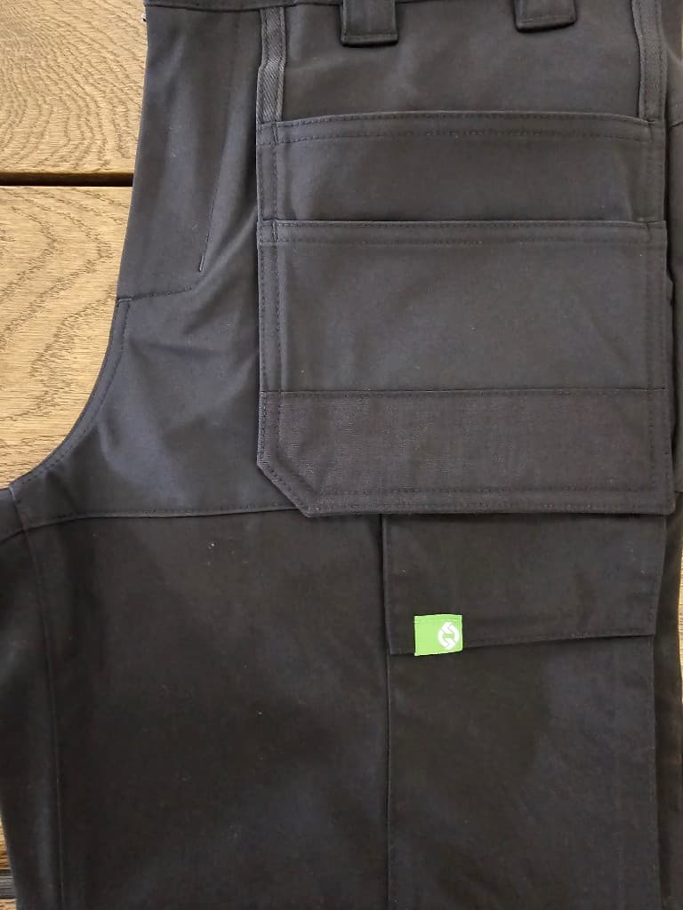 Layered utility cargo pocket construction on technical workwear trousers
